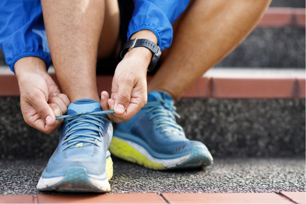 up-close of man lacing up running shoes