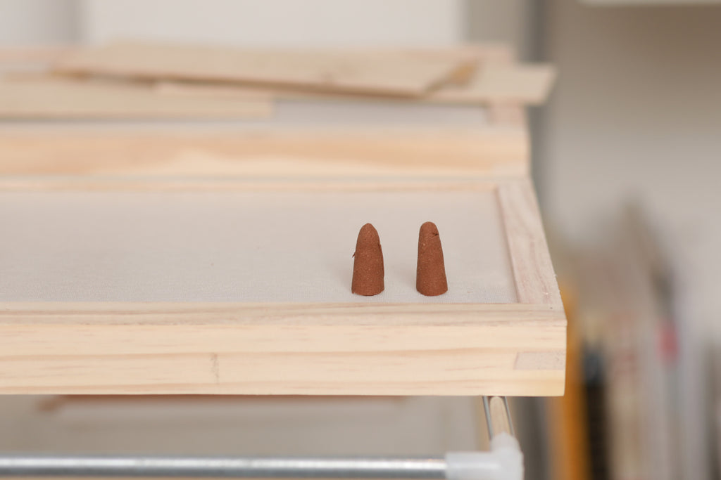 Drying backflow incense cones on a screen