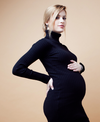 beautiful pregnant woman wearing a black high neck rib-knit dress