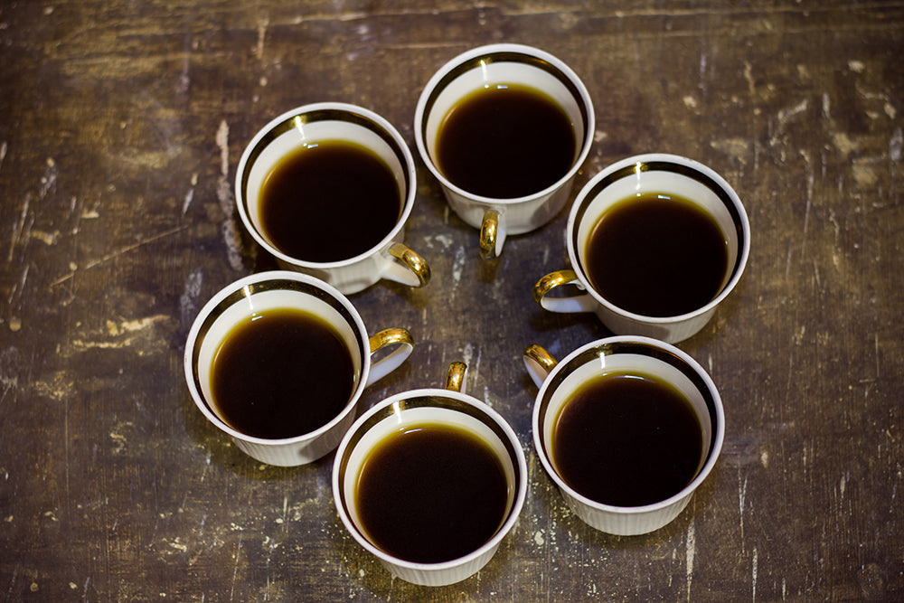 Six coffee cups on a wooden table