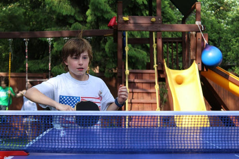 Kid playing Table Tennis in Backyard-Hoe to choose table Tennis Table Guide