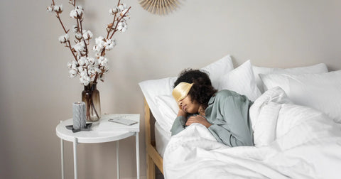 A serene bedroom setting showcasing bedroom decor, with a woman sleeping peacefully while wearing a golden eye mask, and the bed strategically placed for restful energy.