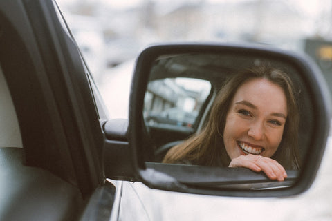 Girl smiles widely in the mirror