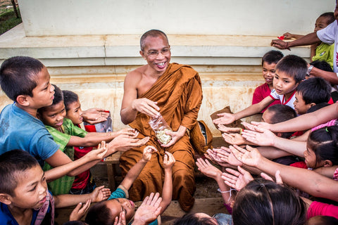 Kind monk giving out to children