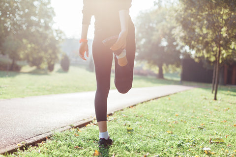 Woman stretching on grass before her workout