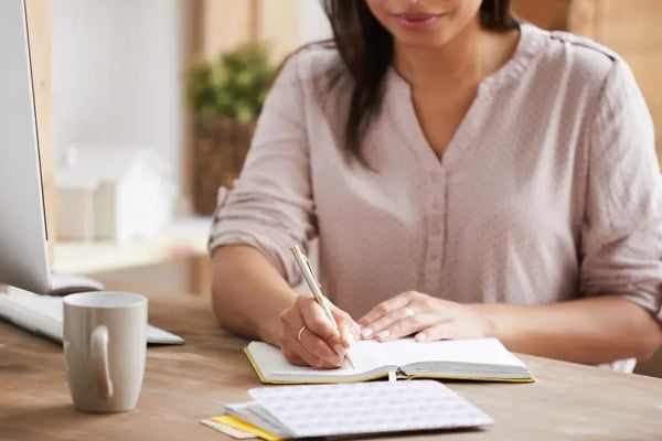 Woman updating her journal and planner.