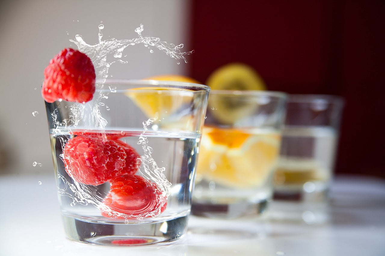 Fruit splashing into glasses of water
