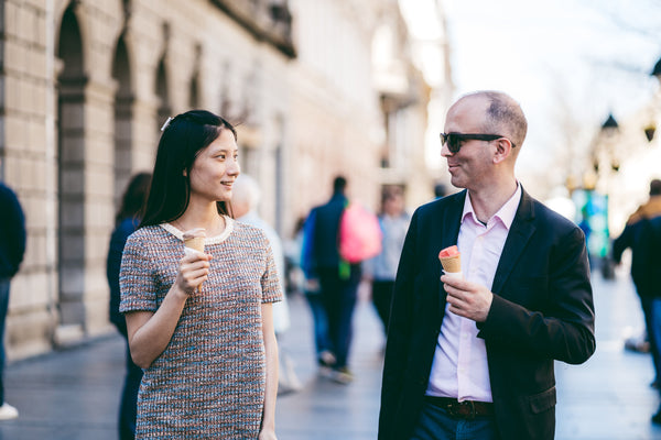Man and woman walking while eating ice cream.