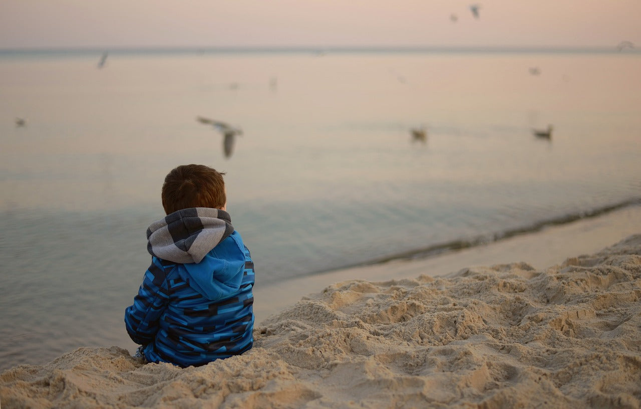 Child looking out at ocean