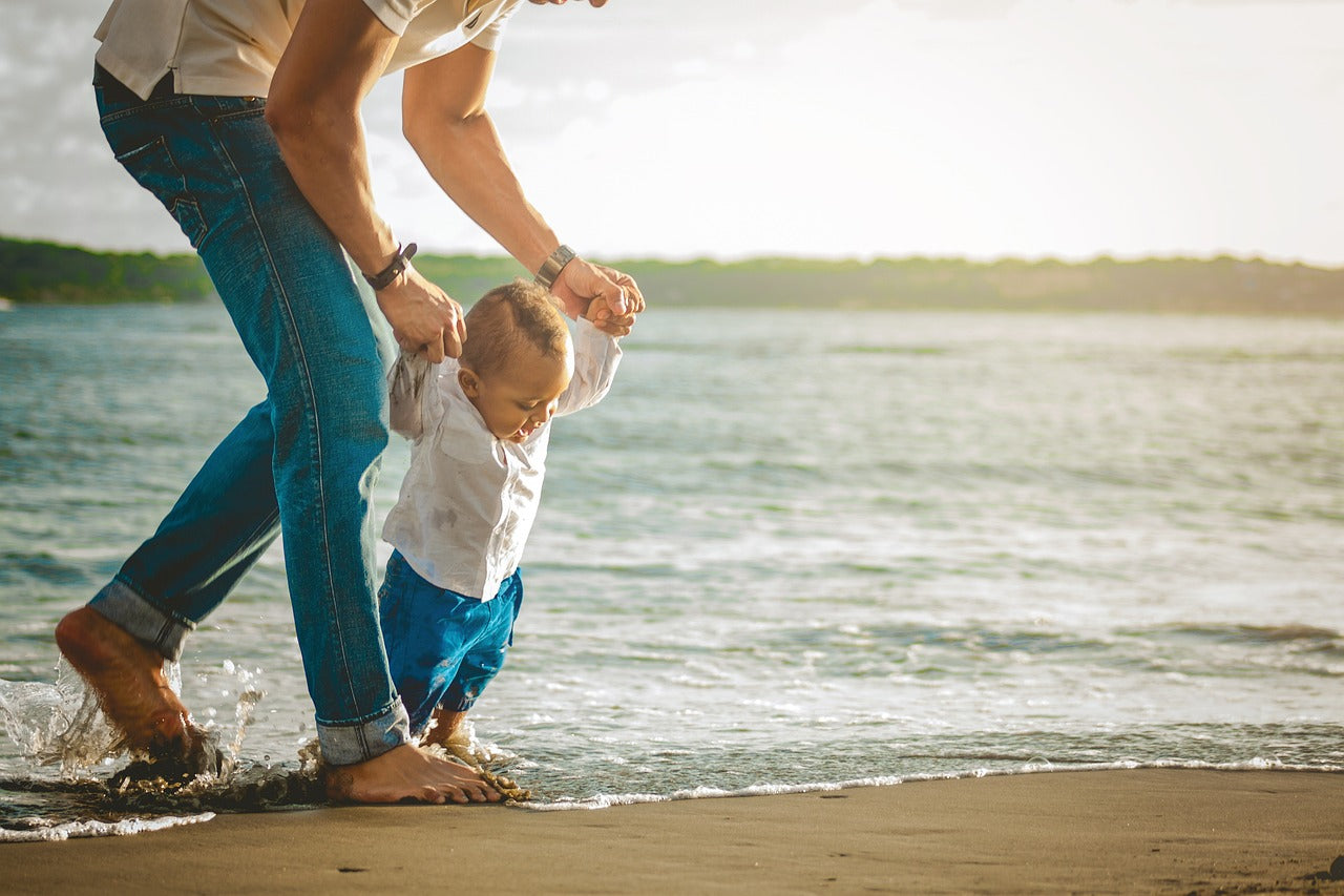 Father walking with child on the beach