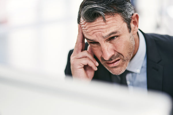 Man looking ovewhelmed with tasks.