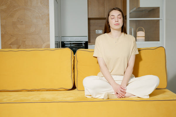 Woman practicing deep breathing indoors.