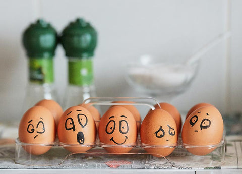 different emotions drawn on 5 brown eggs