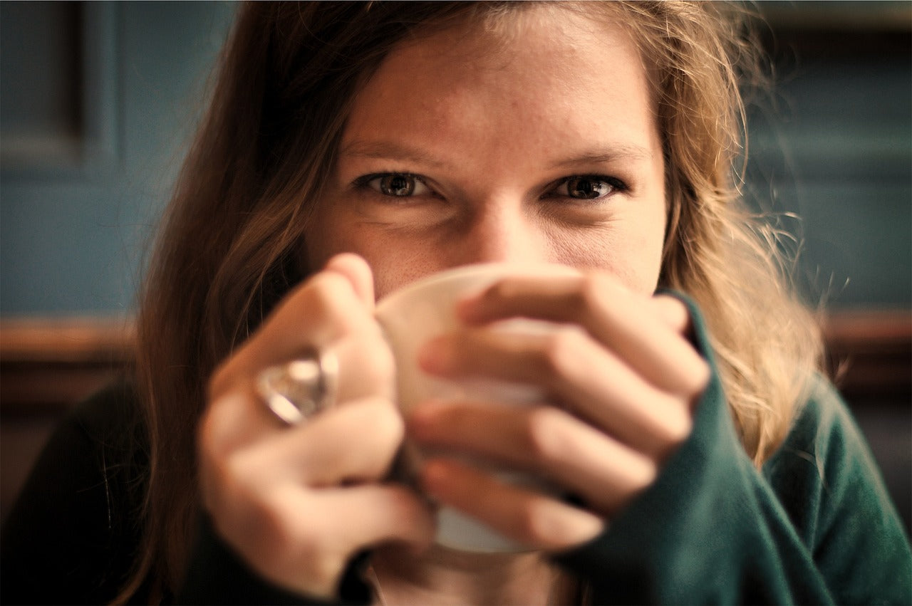 Person smiling while drinking coffee
