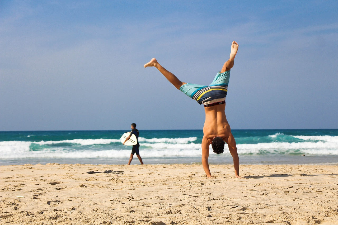 Person doing cartwheel on beach