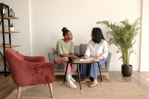 A person sitting peacefully in a therapy session with a supportive therapist.