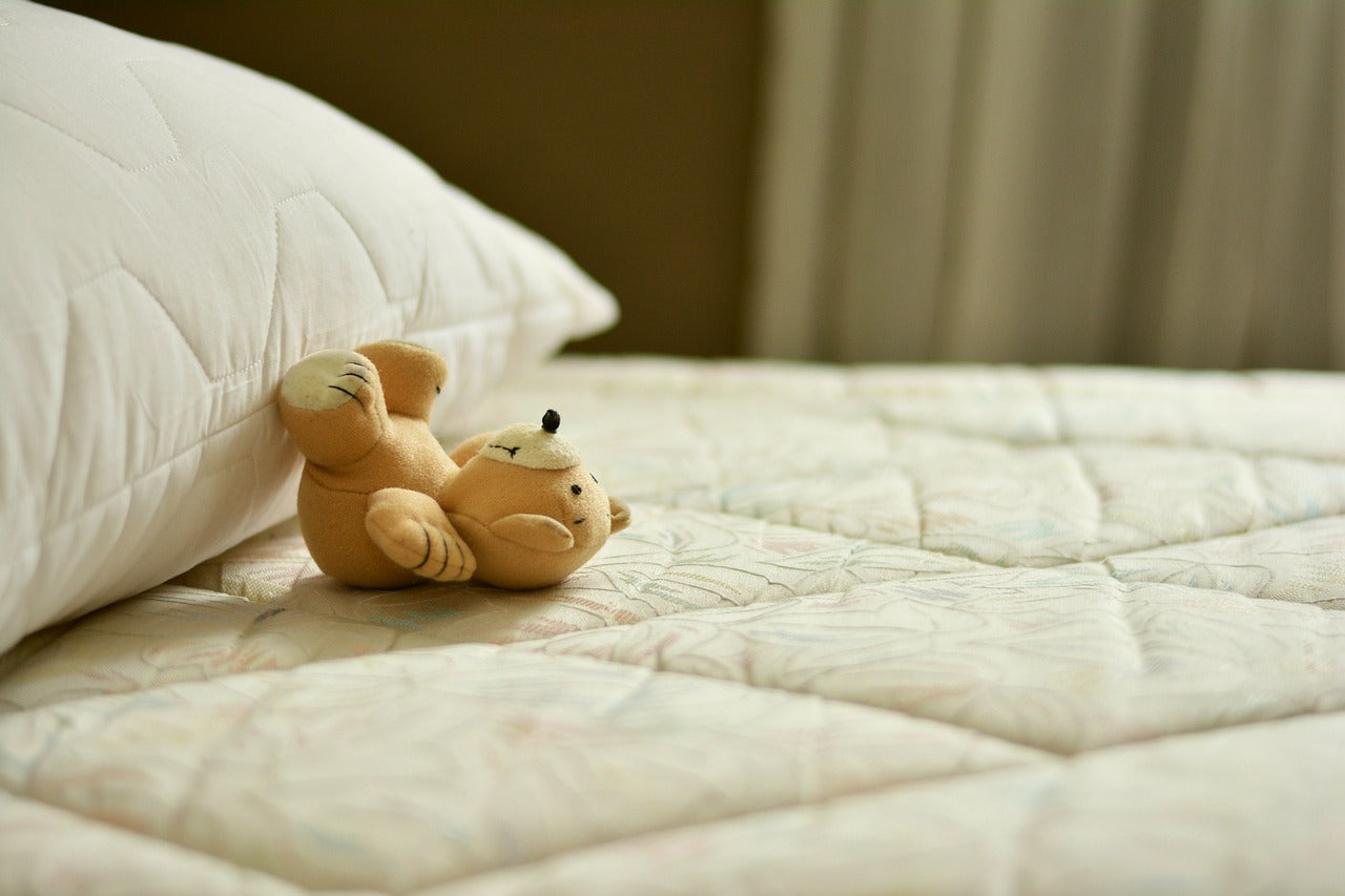 Teddy bear lying on mattress