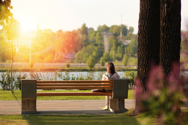 A calm person sitting on a park bench.