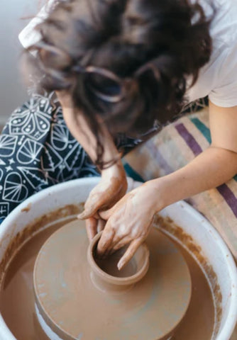 Woman using process of making pottery bowl to relax and cope with stress