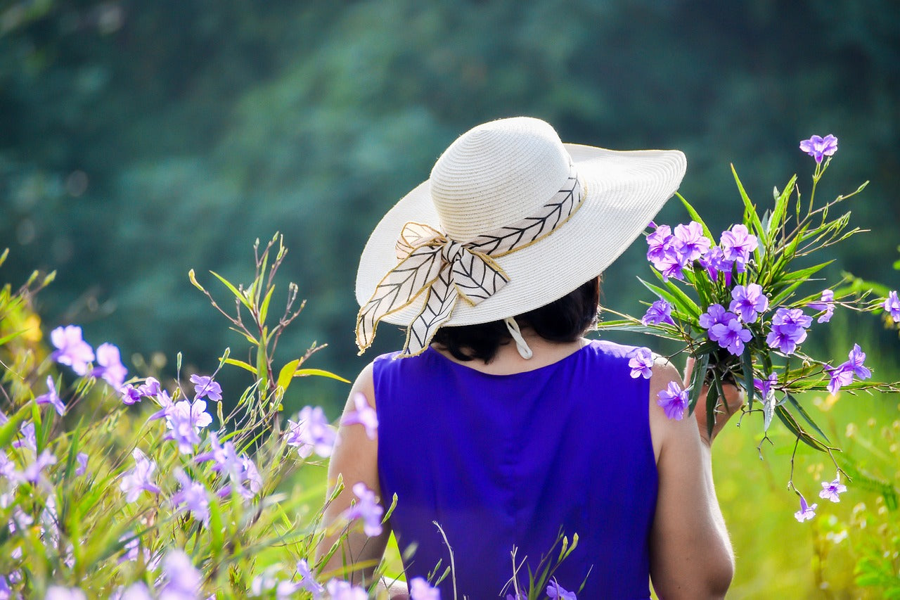 Person in sun hat holding flowers