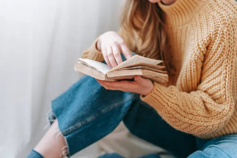 A person reading a book in a cozy corner.