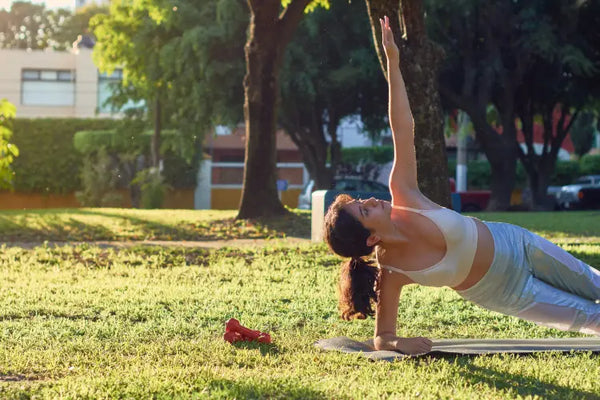 A serene scene with a person practicing yoga in a peaceful outdoor setting.