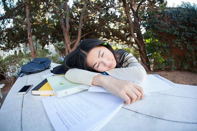 Person asleep on textbooks