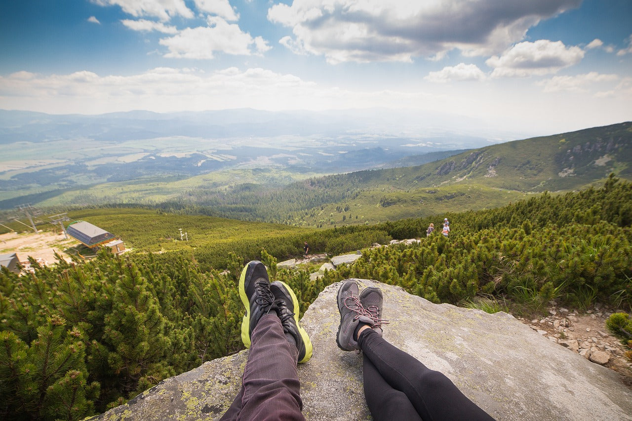 People sitting with legs out overlooking a valley