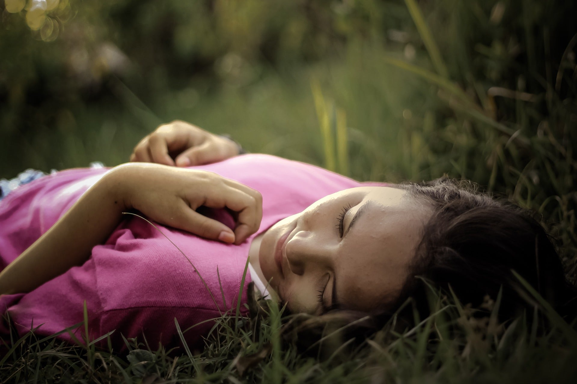 Person lying on their back in grass