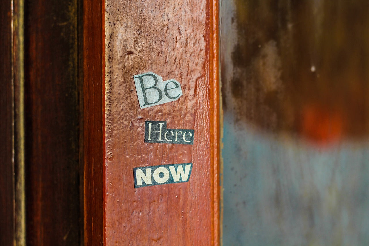 "Be here now" stickers on a doorframe