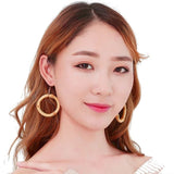 Femme portant 2 boucles d'oreilles en forme d'anneau en bois de bambou