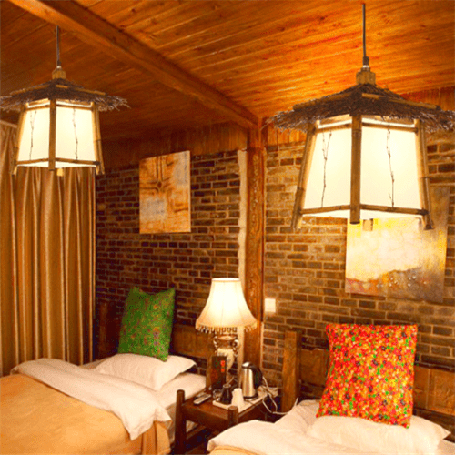 2 candelabros colgantes de bambú y mimbre iluminan un dormitorio