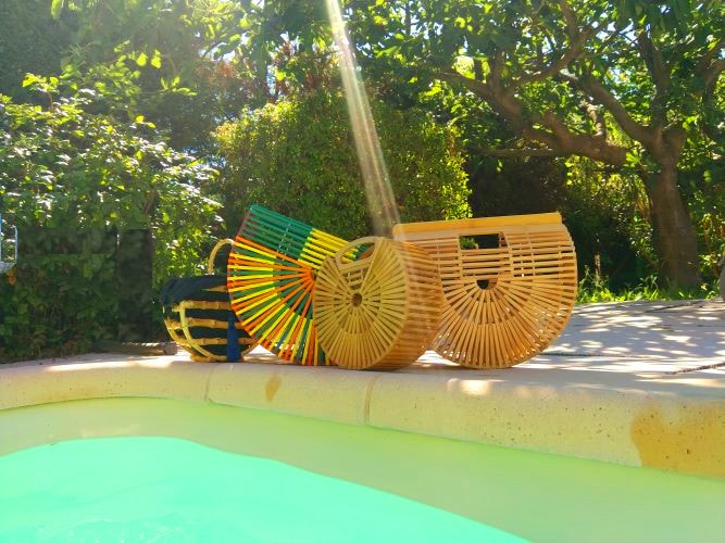 4 sacs à main au bord d'une piscine : 1 anse en bambou en forme de demi lune, 2 en forme d'arche parfait pour aller à la plage et 1 rond pour le shopping