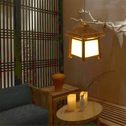 Araña colgante de bambú y ratán en una habitación zen con velas. lámpara colgante de rama de madera
