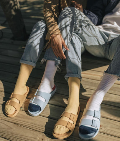 casal sentado lado a lado com sandálias Linus nos pés