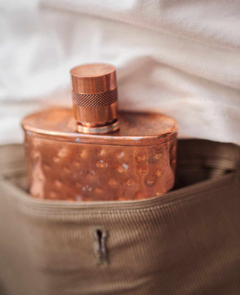 Jacob Bromwell Legacy Copper Flask en el bolsillo trasero de un pantalón de vestir