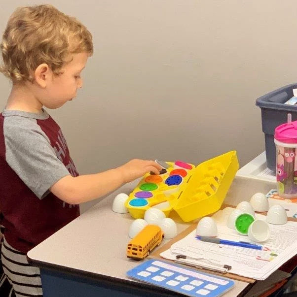 Young boy at a table playing with toys