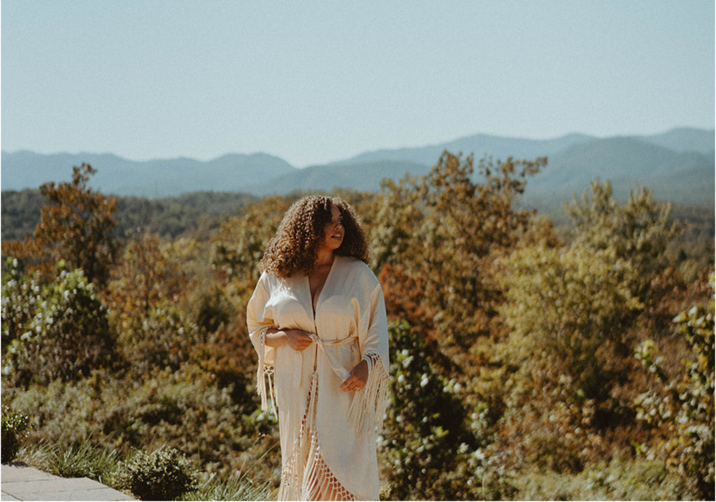 woman standing in robe at mountain top