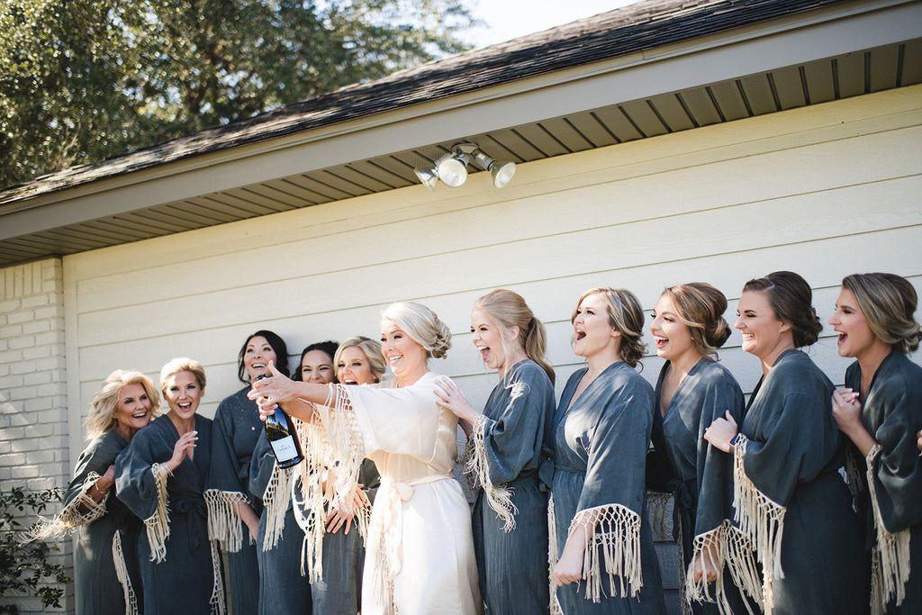 bride popping champagne in robe