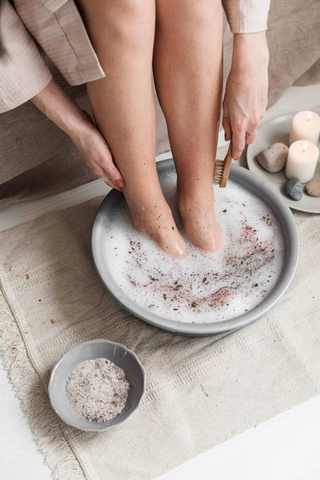 Lady with feet soaking in a bowl of frothy water