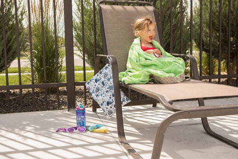 Little girl sitting pool side with a wet bag from The Everyday Green