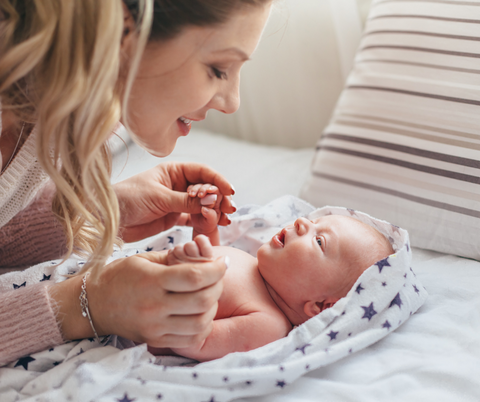 Young mother looking at her infant, both are smiling