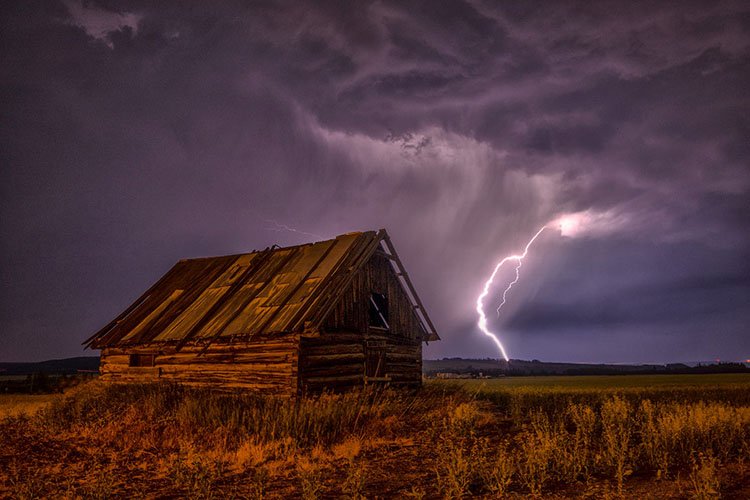 A purple and astonishing lightning strikes next to a wooden cabinet