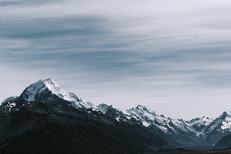 Mountains under snow with moving clouds on top captured on long exposure