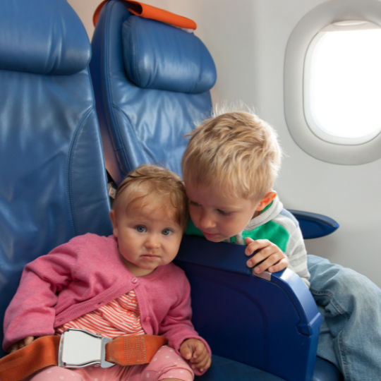 Brother and sister on a plane with window in the background