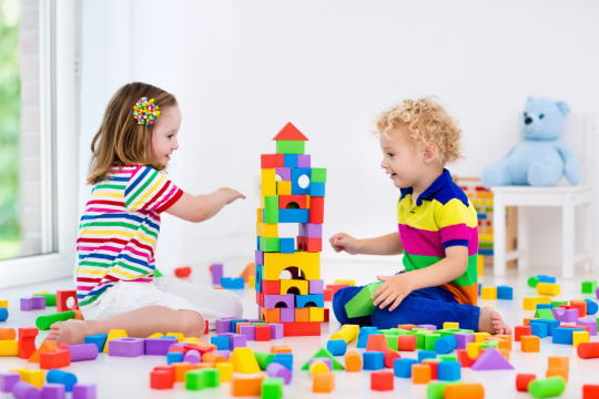 Young boy and girl playing with building blocks