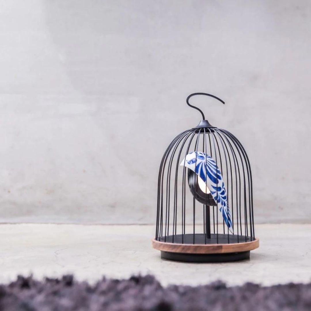 A lighting fixture with a bird in a birdcage.