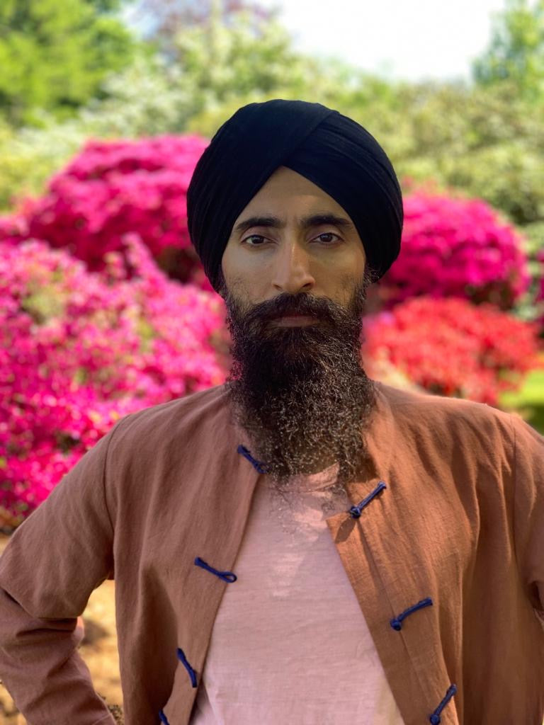 waris ahluwalia standing in a field of flowers