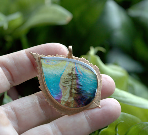 bronze pendant featuring 'hanging on' image