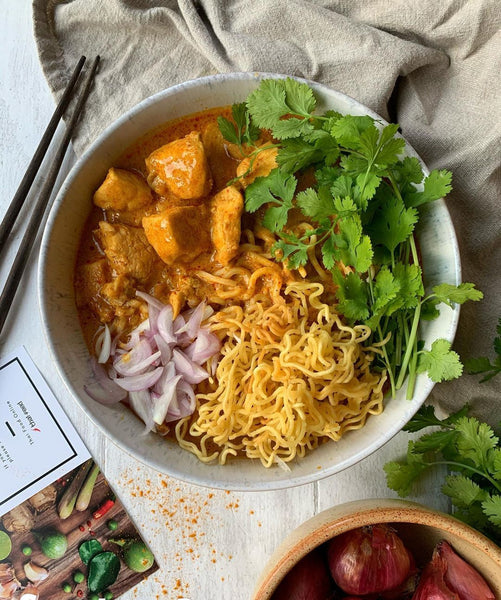 Khao Soi garnished with coriander and shallots